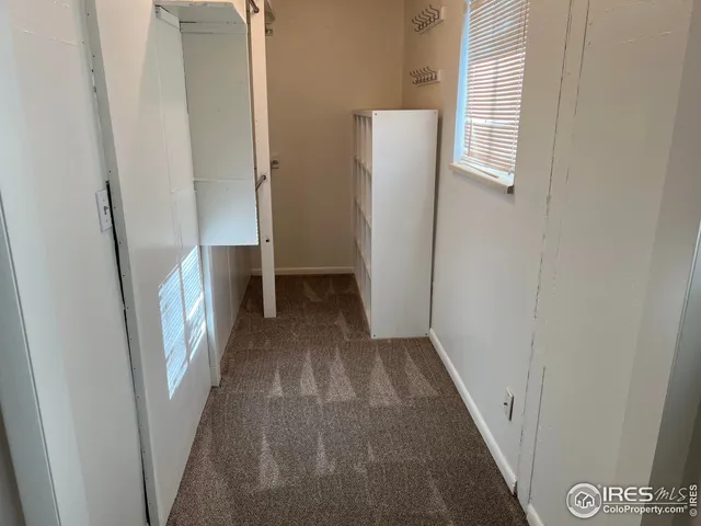 a view of walk in closet with clothes