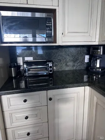 a kitchen with white cabinets and black appliances