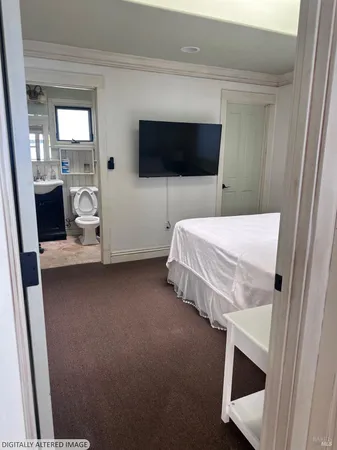 a bed room with a bed tv and a window