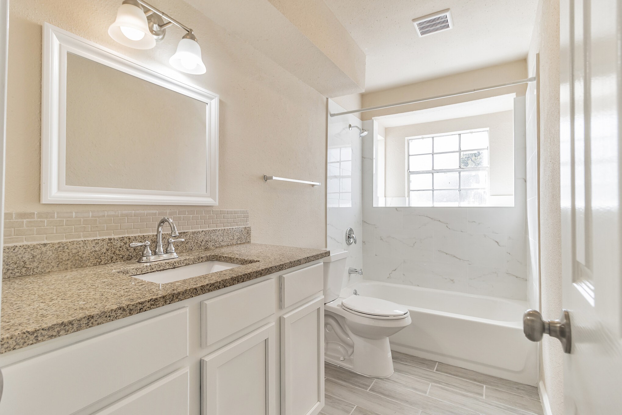 6815 Beachwood Street, Unit 1 Houston, TX 77021 - Photo 14 of 20 a bathroom with a granite countertop toilet a sink and a bathtub