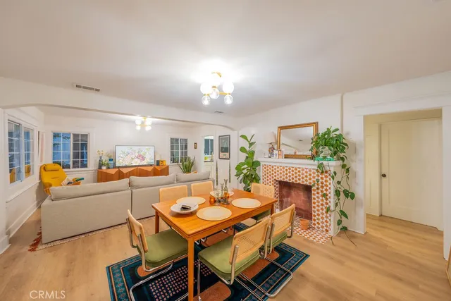 a living room with furniture a fireplace and potted plants