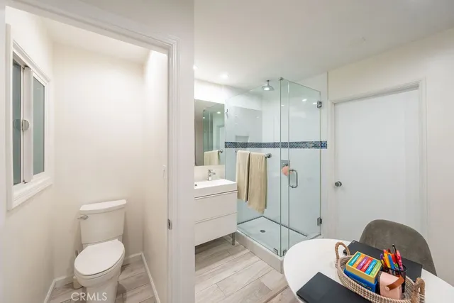 an empty room with wooden floor closet and windows