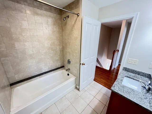 a bathroom with a granite countertop sink a mirror and shower
