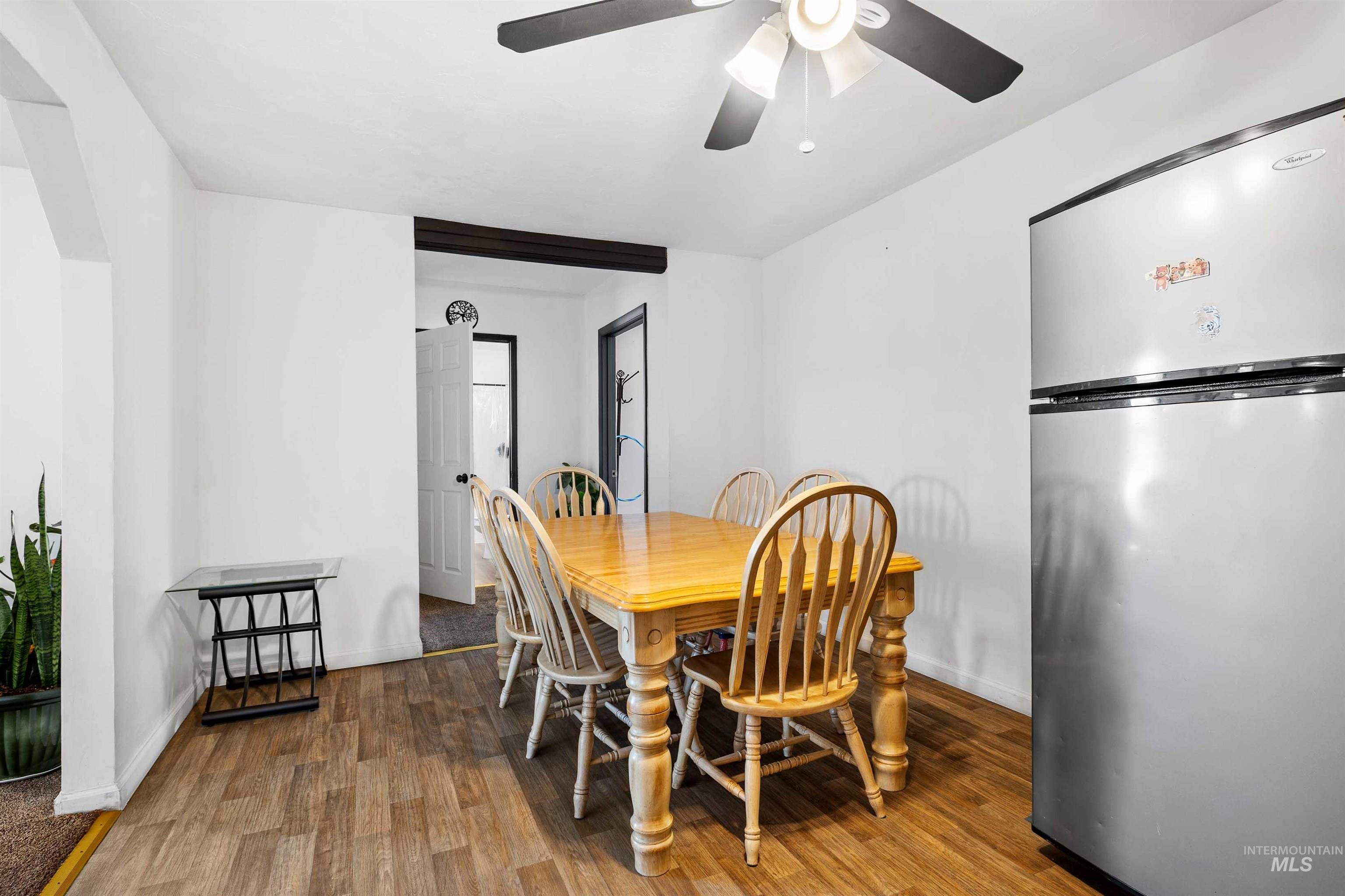 102 East 6th Street Rupert, ID 83350 - Photo 11 of 27 Dining area featuring wood-finish flooring, a ceiling fan with integrated lighting, and a stainless steel refrigerator