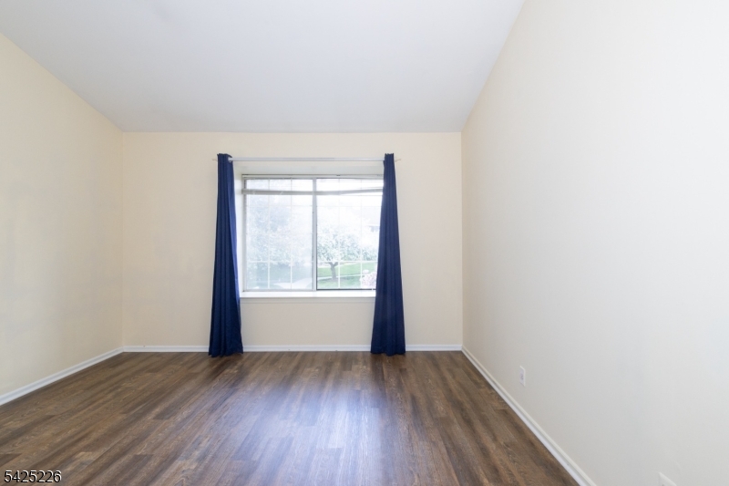 90 Mayfield Road, Unit 90 Bedminster, NJ 07921 - Photo 18 of 38 a view of an empty room with wooden floor and a window