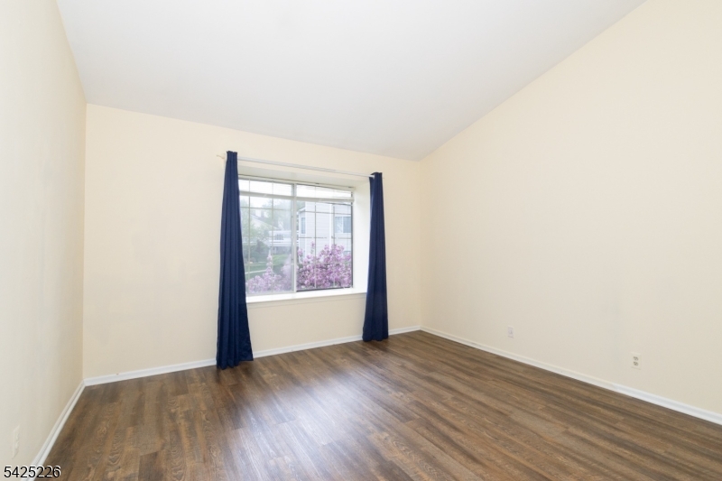 90 Mayfield Road, Unit 90 Bedminster, NJ 07921 - Photo 19 of 38 a view of an empty room with wooden floor and a window