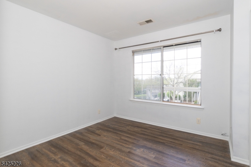 90 Mayfield Road, Unit 90 Bedminster, NJ 07921 - Photo 20 of 38 an empty room with wooden floor and windows