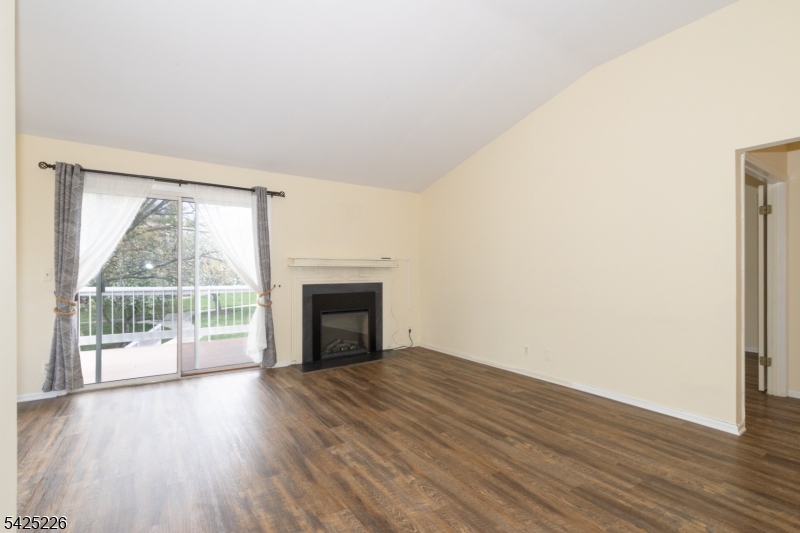 90 Mayfield Road, Unit 90 Bedminster, NJ 07921 - Photo 7 of 38 an empty room with wooden floor and fireplace