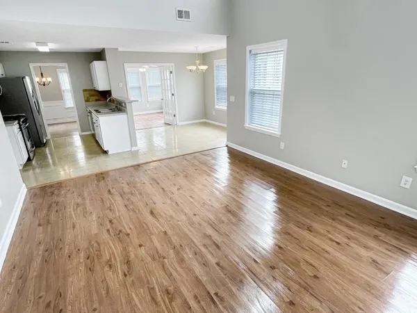 a view of a living room and kitchen with wooden floor