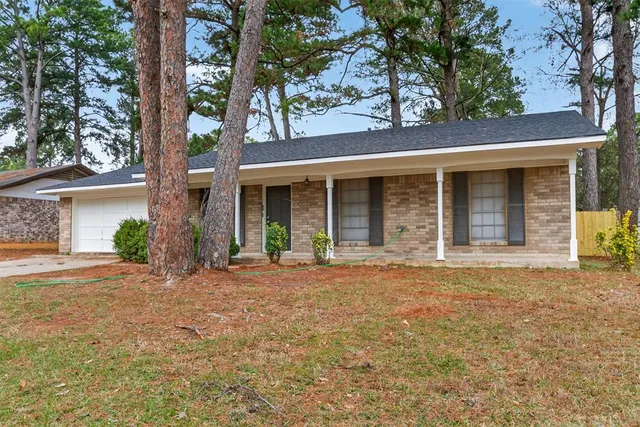 a view of a house with large windows and a tree