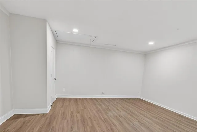 an empty room with wooden floor chandelier fan and windows