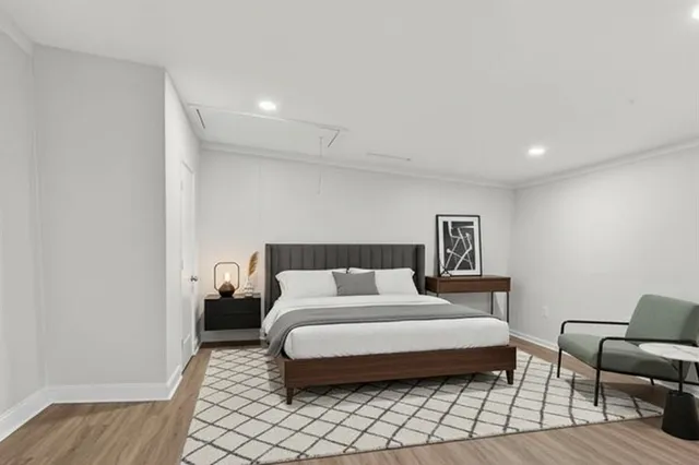 a spacious bedroom with a bed and a flat screen tv