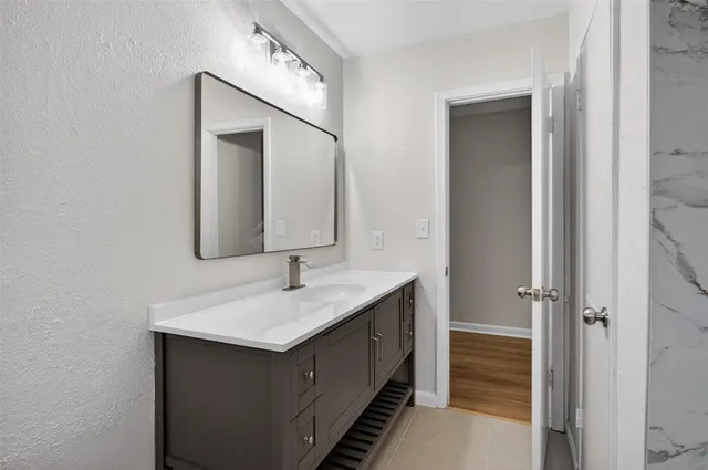 an empty room with wooden floor and a ceiling fan
