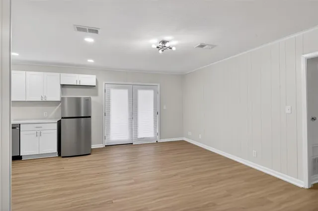 a view of an empty room with wooden floor
