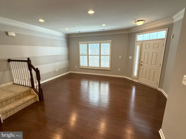 a view of a bedroom with wooden floor and a window