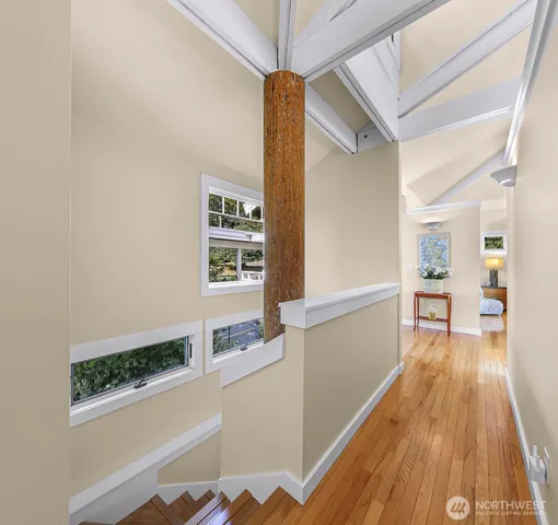 a view of a hallway with wooden floor and staircase