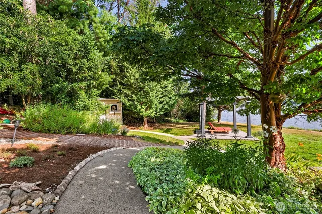 a backyard of a house with table and chairs under an umbrella