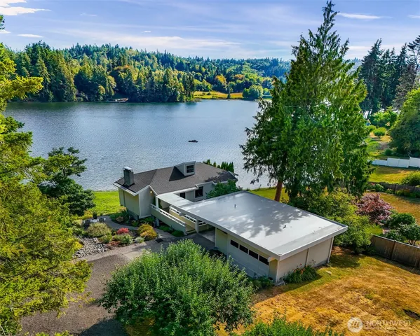 an aerial view of a house with a yard and lake view