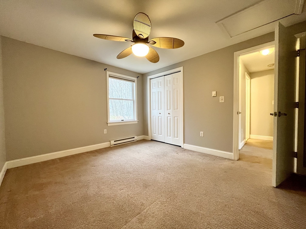 11 Jones Landing, Unit B Walpole, MA 02081 - Photo 12 of 18 an empty room with a chandelier fan and windows