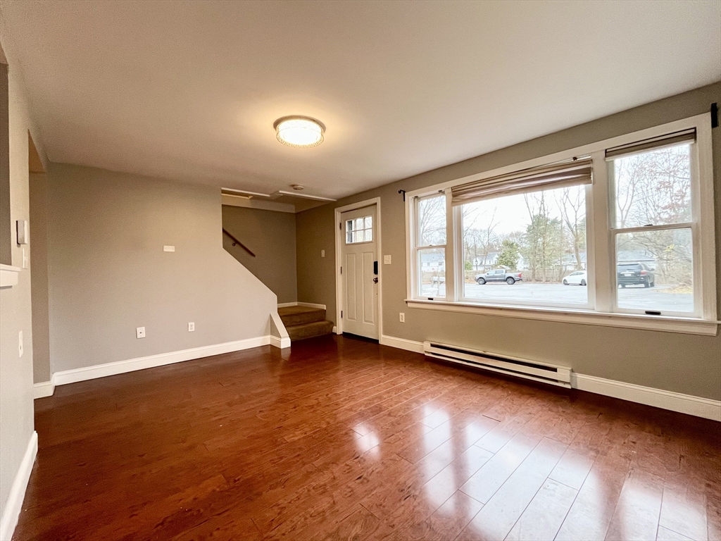 11 Jones Landing, Unit B Walpole, MA 02081 - Photo 4 of 18 an empty room with wooden floor and windows