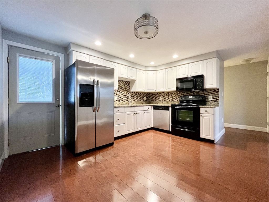 11 Jones Landing, Unit B Walpole, MA 02081 - Photo 5 of 18 a kitchen with stainless steel appliances granite countertop a stove top oven a sink and a refrigerator