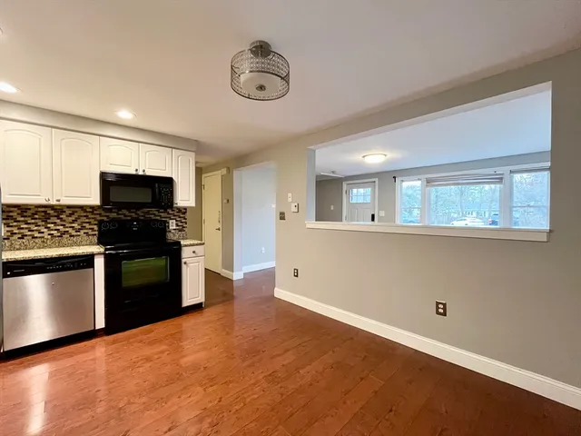 a kitchen with granite countertop white cabinets and stainless steel appliances