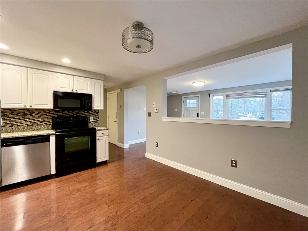 11 Jones Landing, Unit B Walpole, MA 02081 - Photo 7 of 18 a kitchen with granite countertop white cabinets and stainless steel appliances