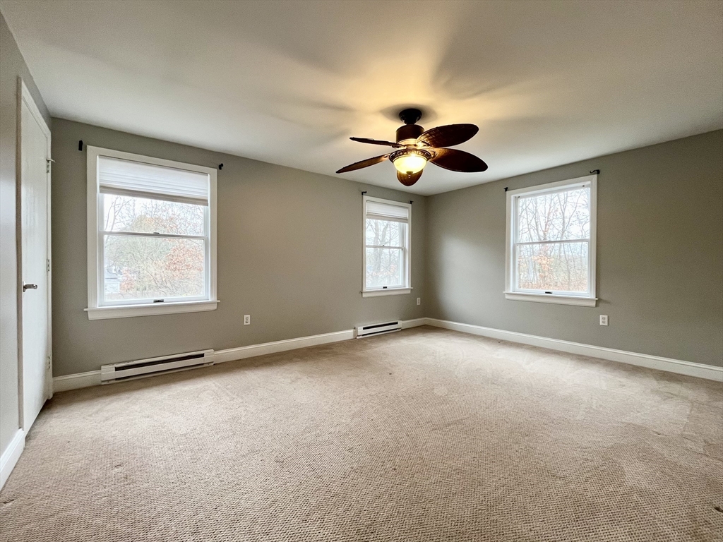 11 Jones Landing, Unit B Walpole, MA 02081 - Photo 10 of 18 a view of an empty room with windows and ceiling fan