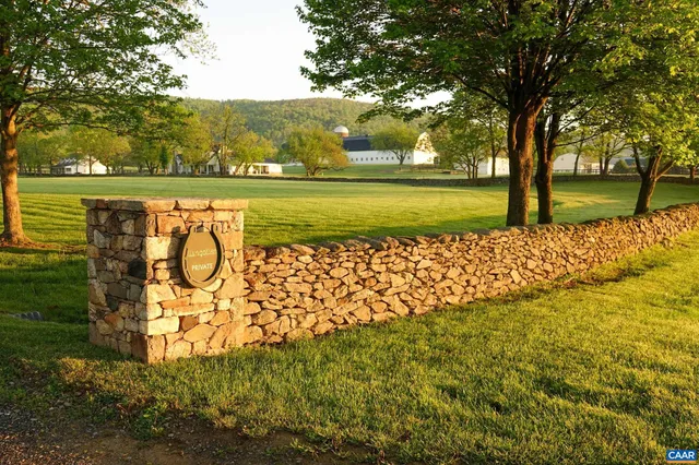 a view of swimming pool with an outdoor seating and large trees