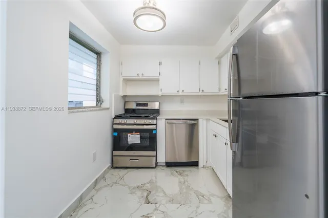 a kitchen with a refrigerator and a stove top oven