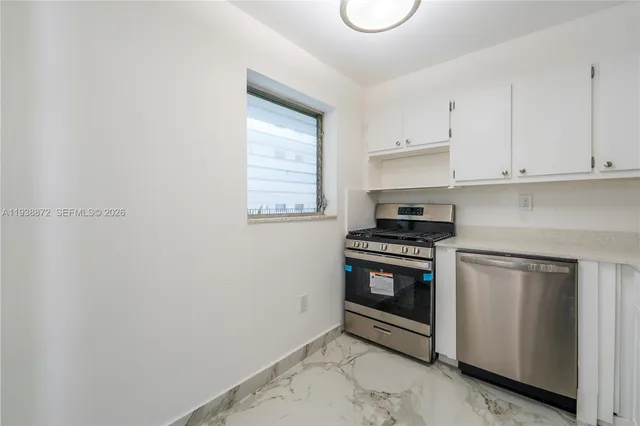 a kitchen with white cabinets and appliances