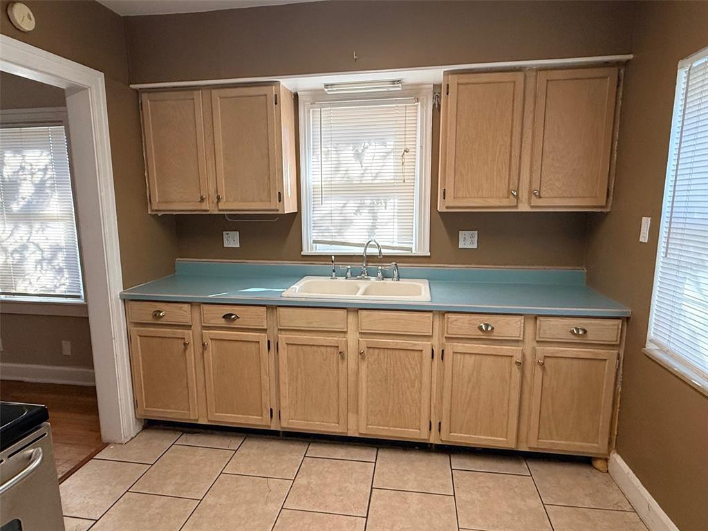 1908 20th Avenue North St. Petersburg, FL 33713 - Photo 11 of 39 a kitchen with granite countertop white cabinets sink and a window
