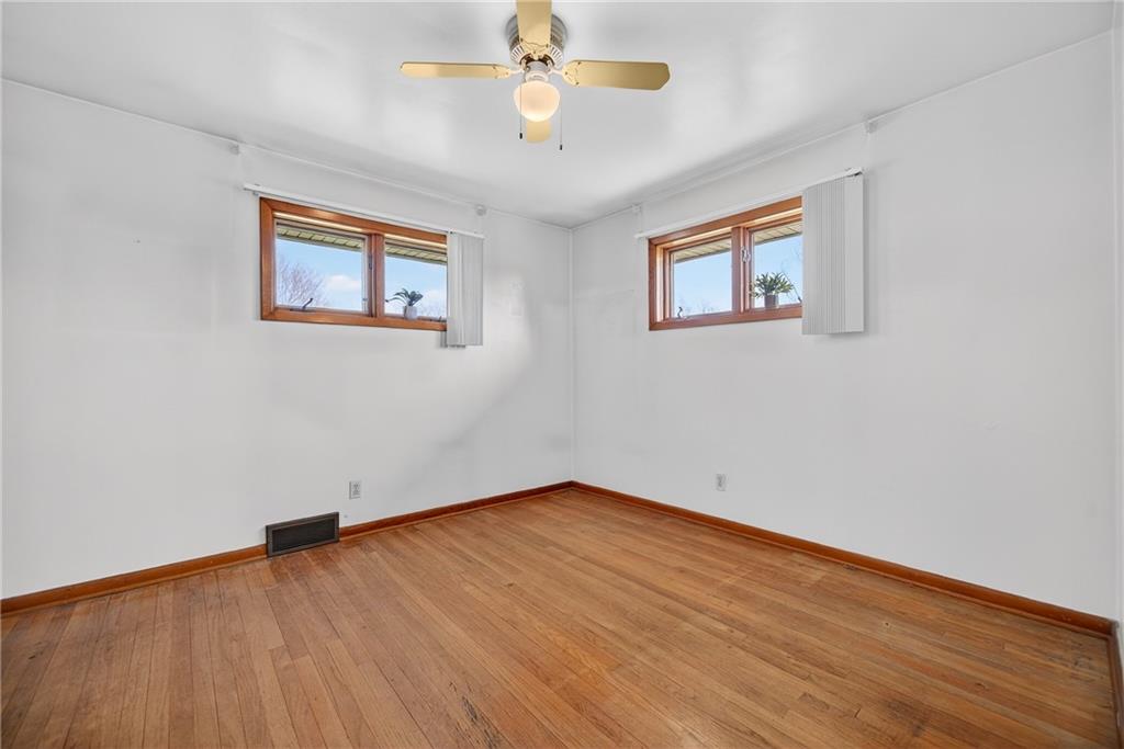 105 Clearview Drive Baden, PA 15005 - Photo 20 of 43 an empty room with wooden floor ceiling fan and windows