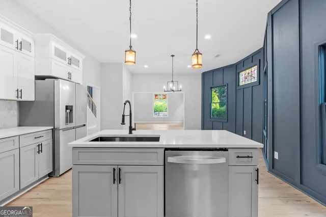 a kitchen with kitchen island a sink appliances and cabinets