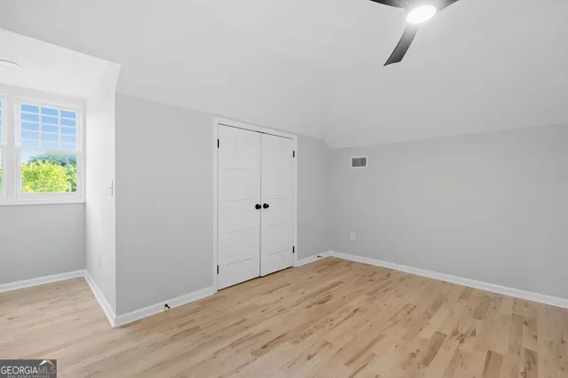a view of empty room with wooden floor