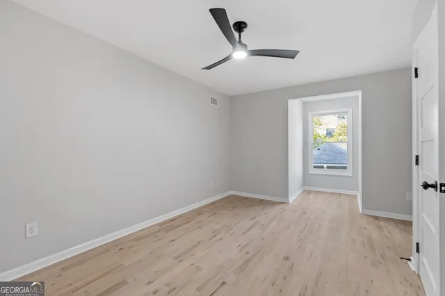 a view of empty room with wooden floor
