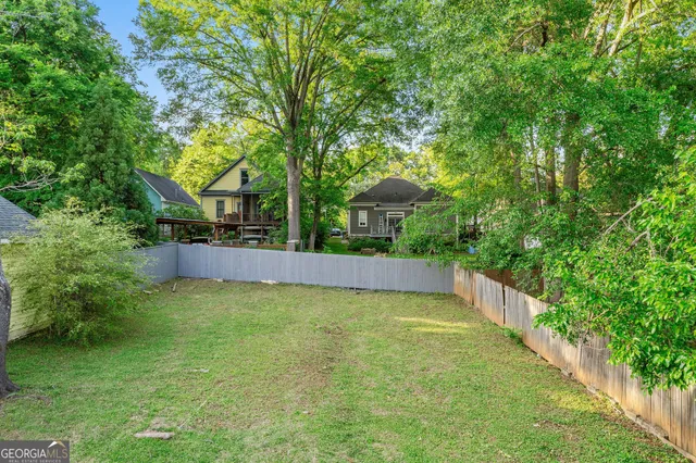 a view of a backyard with a small deck and a garden