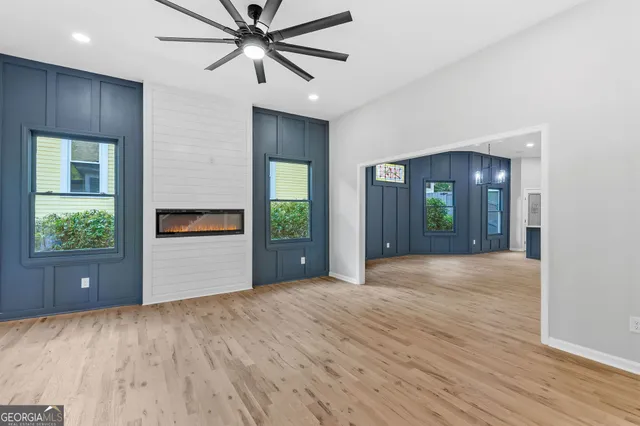 a view of an empty room with a window and wooden floor