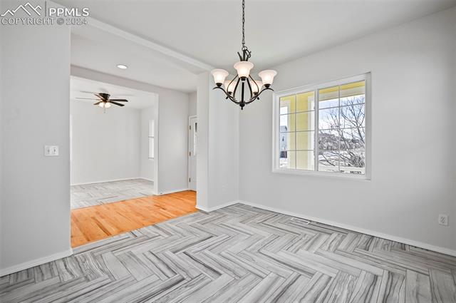 10165 Angeles Road Peyton, CO 80831 - Photo 17 of 38 Empty room with ceiling fan with notable chandelier and light parquet floors