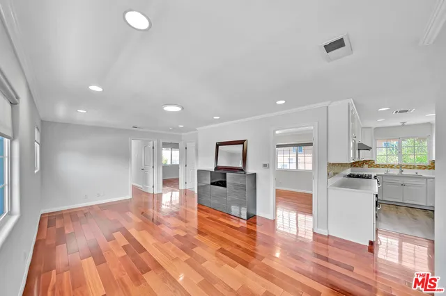 a large kitchen with cabinets and wooden floor