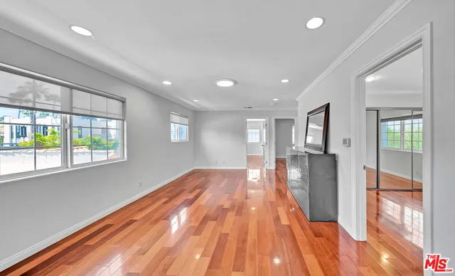 a view of empty room with wooden floor and windows