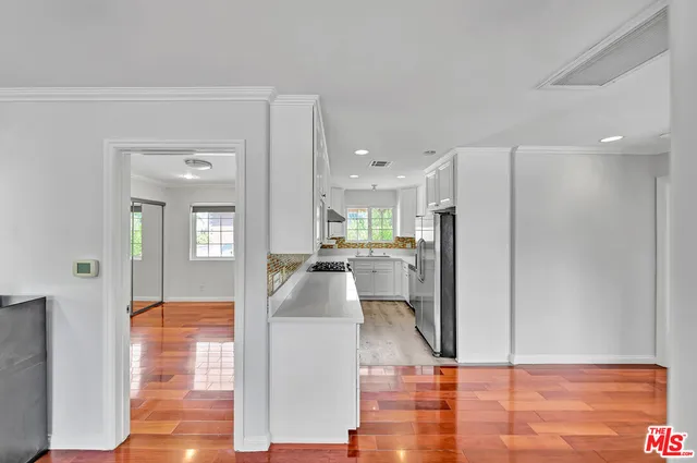 a living room with stainless steel appliances kitchen island granite countertop furniture and a rug