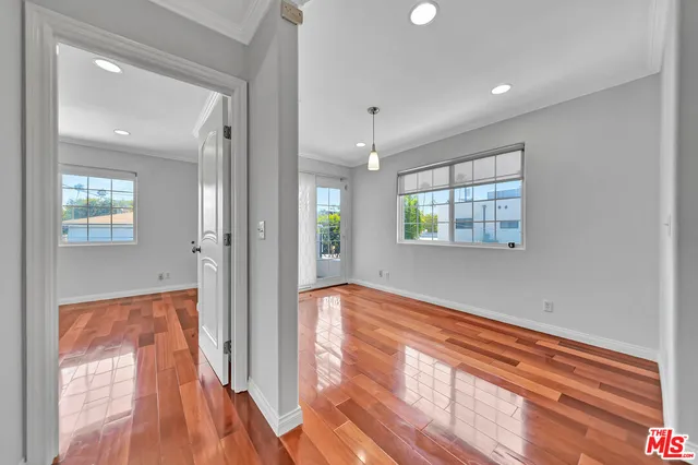 a view of hallway with a large window and wooden floor