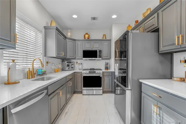 a kitchen with stainless steel appliances a stove sink microwave and cabinets