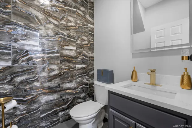 a bathroom with a granite countertop toilet and sink