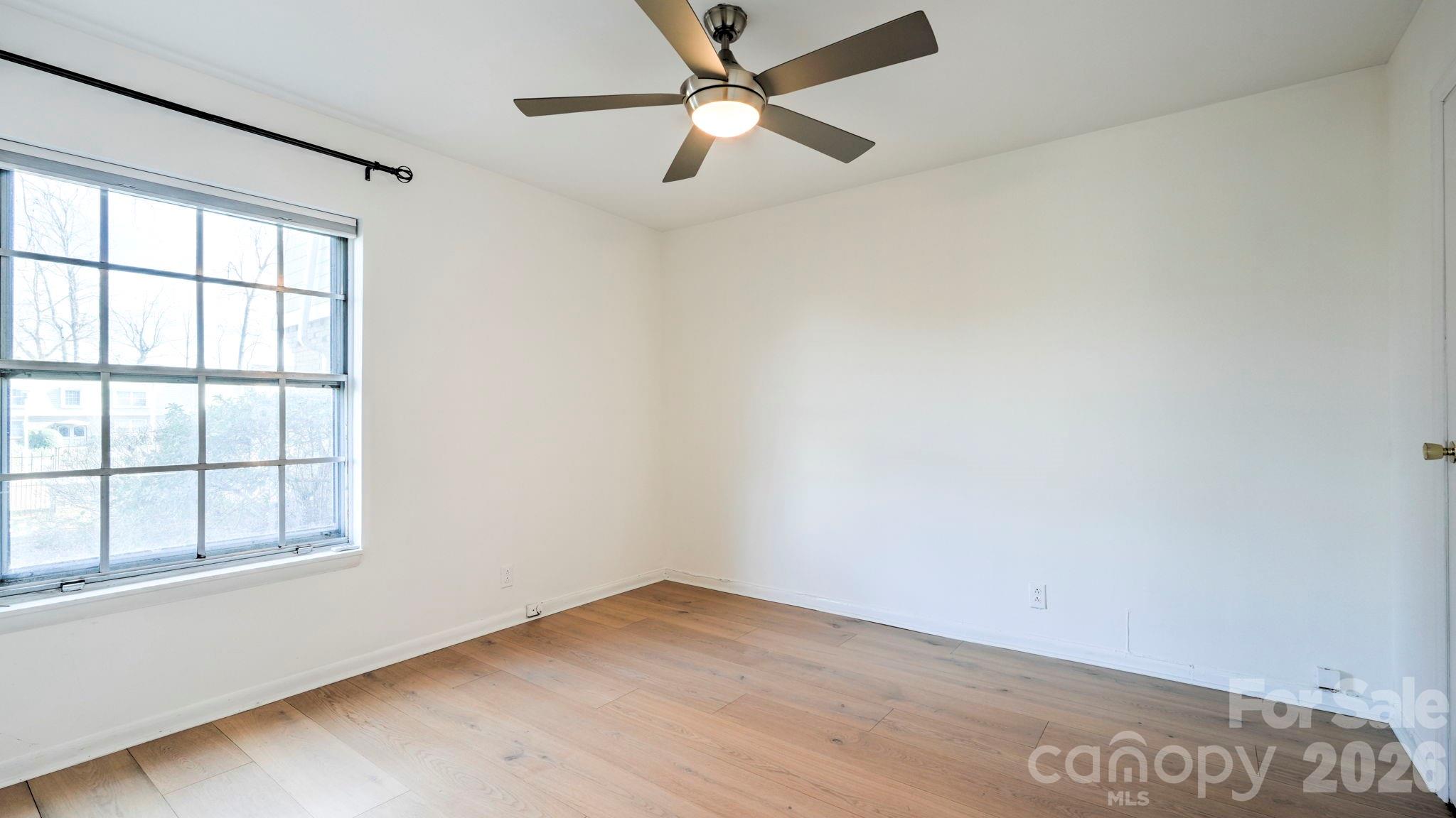 2626 Park Road, Unit B Charlotte, NC 28209 - Photo 16 of 31 an empty room with a window and a ceiling fan