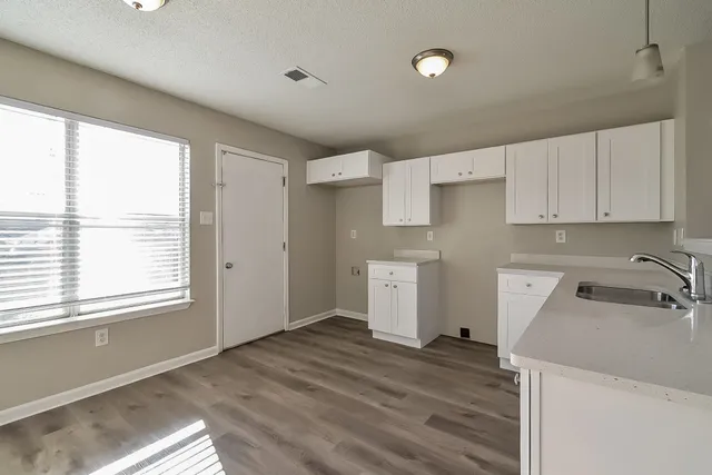 a view of a kitchen with wooden floor and electronic appliances