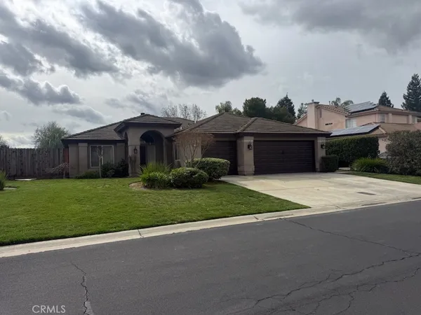 a front view of a house with a garden and yard