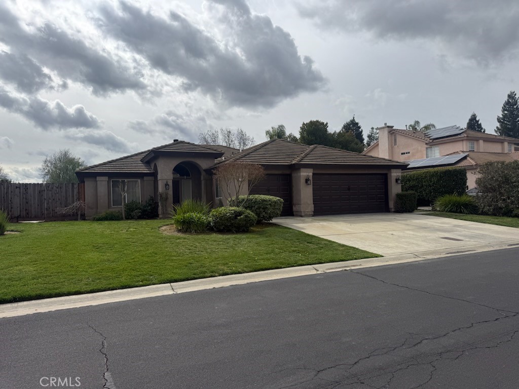 7290 Edgewater Street Chowchilla, CA 93610 - Photo 1 of 1 a front view of a house with a garden and yard