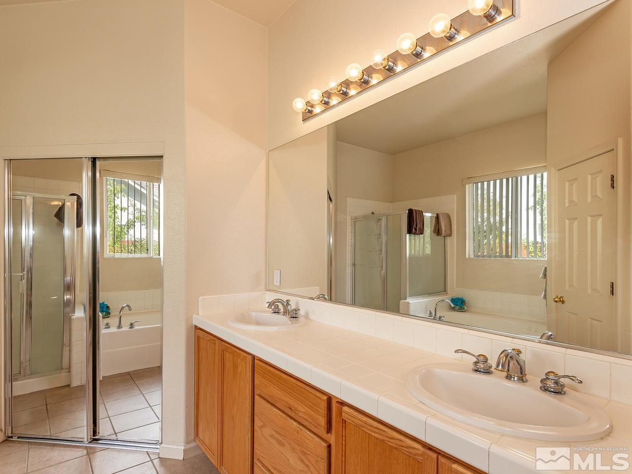 10675 Silver Cliff Way Reno, NV 89521 - Photo 12 of 16 a bathroom with a sink double vanity and a shower